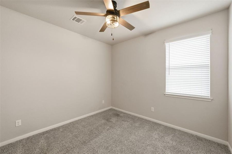 Empty room featuring carpet floors and a ceiling fan