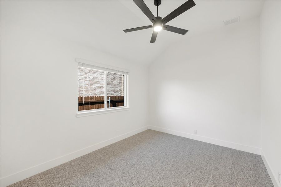 Empty bedroom with gray carpet, white walls, black ceiling fan, and single window Empty bedroom with gray carpet, white walls, black ceiling fan, and single window