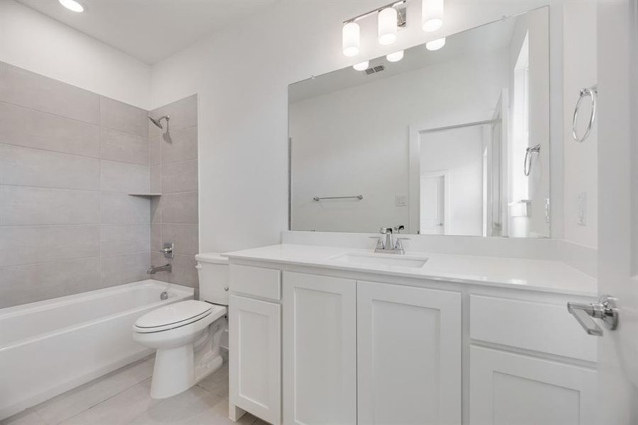 Bathroom with shower / bathtub combination, vanity, and light tile patterned floors