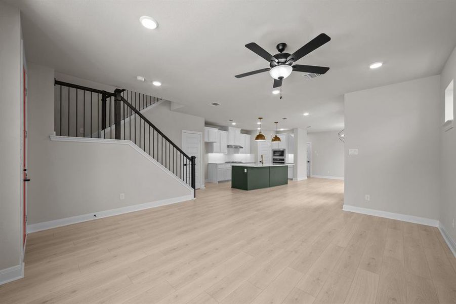 Unfurnished living room with a ceiling fan, recessed lighting, and light wood-type flooring