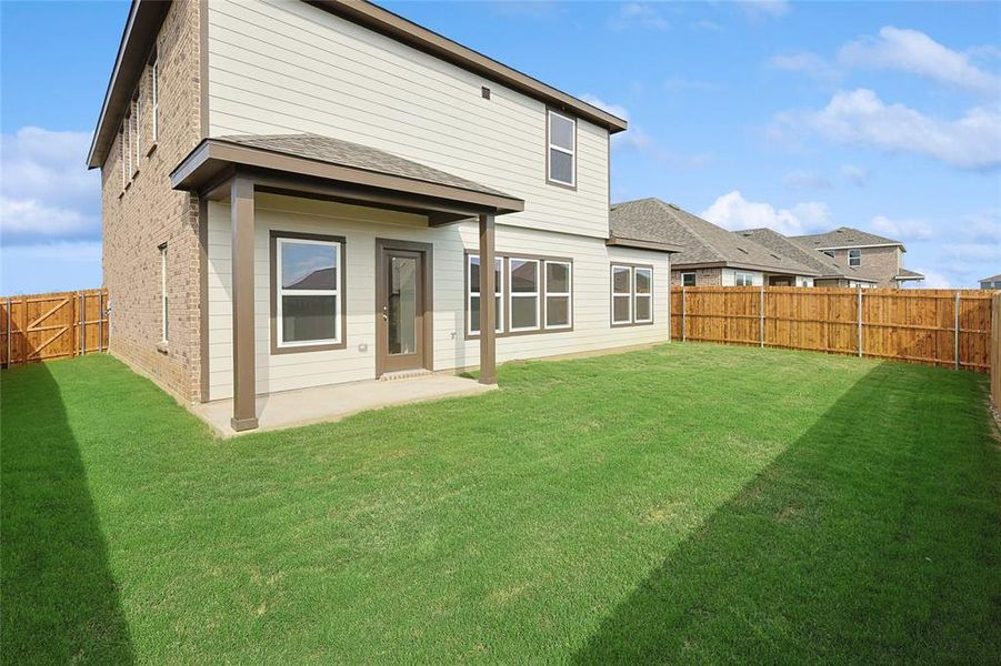 Rear view of property with a patio and a lawn