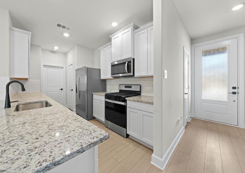 The kitchen of the Cedar has beautiful white wood cabinets.