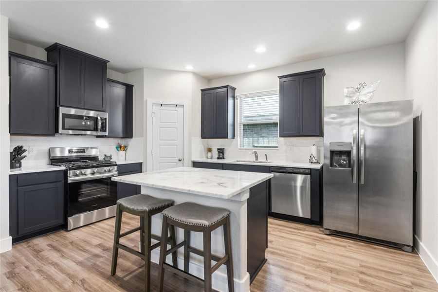 Experience culinary delight in a sleek kitchen featuring a central island, perfect for gatherings and meal prep. Experience culinary delight in a sleek kitchen featuring a central island, perfect for gatherings and meal prep.