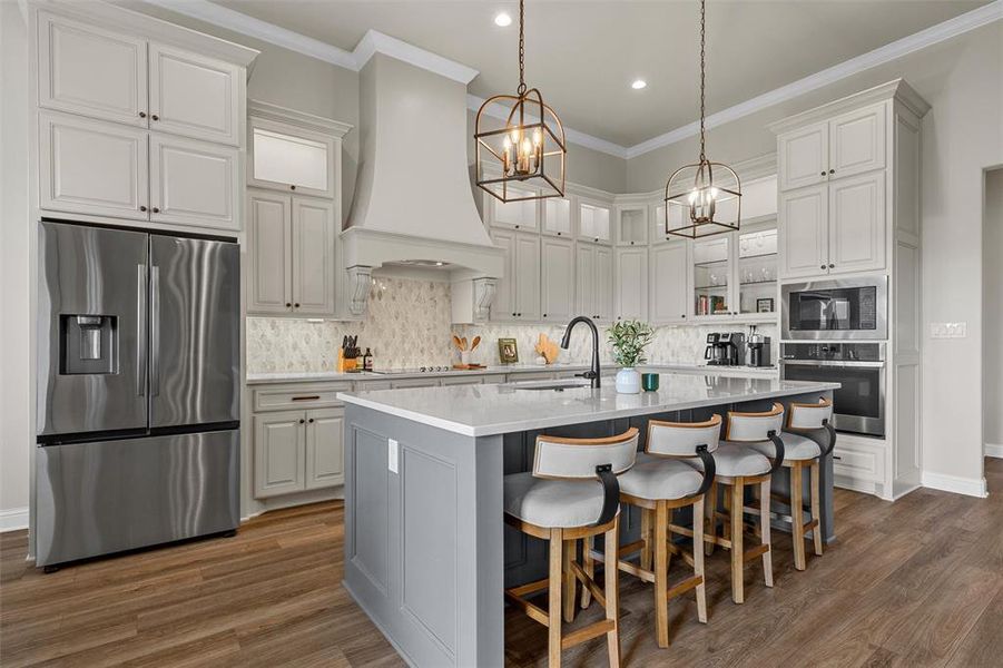 Kitchen featuring an expansive center island, stainless appliances, and built-in cabinetry with spice drawers. Kitchen featuring an expansive center island, stainless appliances, and built-in cabinetry with spice drawers.