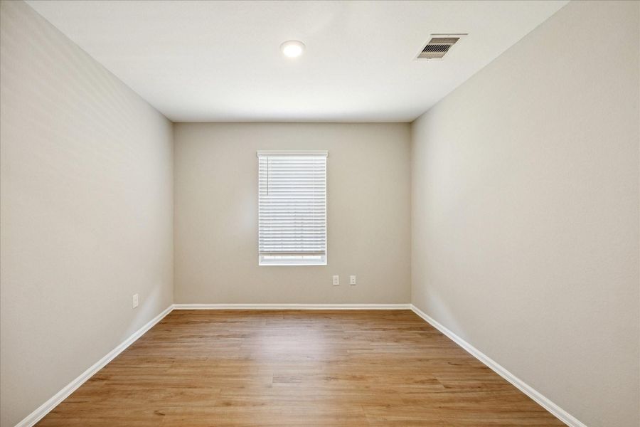 The Home Office/Study features neutral-toned walls and vinyl flooring, with a single window allowing natural light to fill the space.