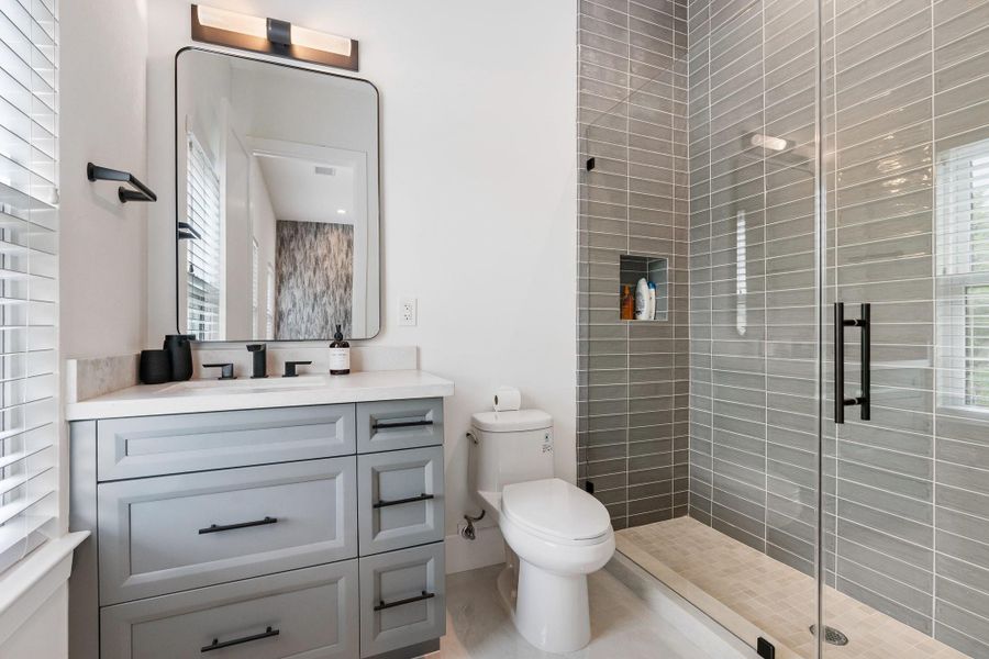 This bathroom offers a walk in shower and tile that reaches the ceiling. This bathroom offers a walk in shower and tile that reaches the ceiling.