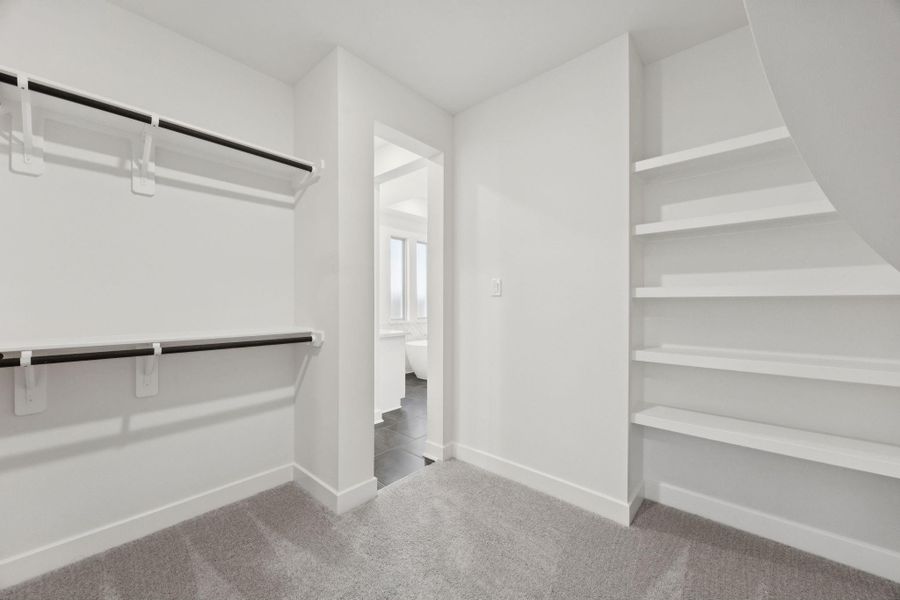 The primary suite features two spacious walk-in closets, providing ample room for clothing, shoes, and personal belongings.