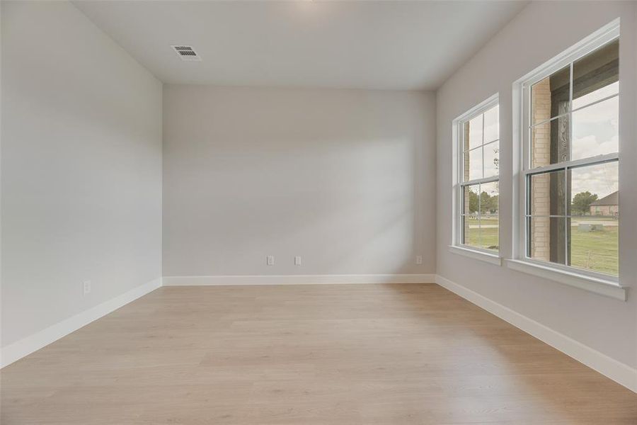Unfurnished room featuring light wood-style floors and baseboards