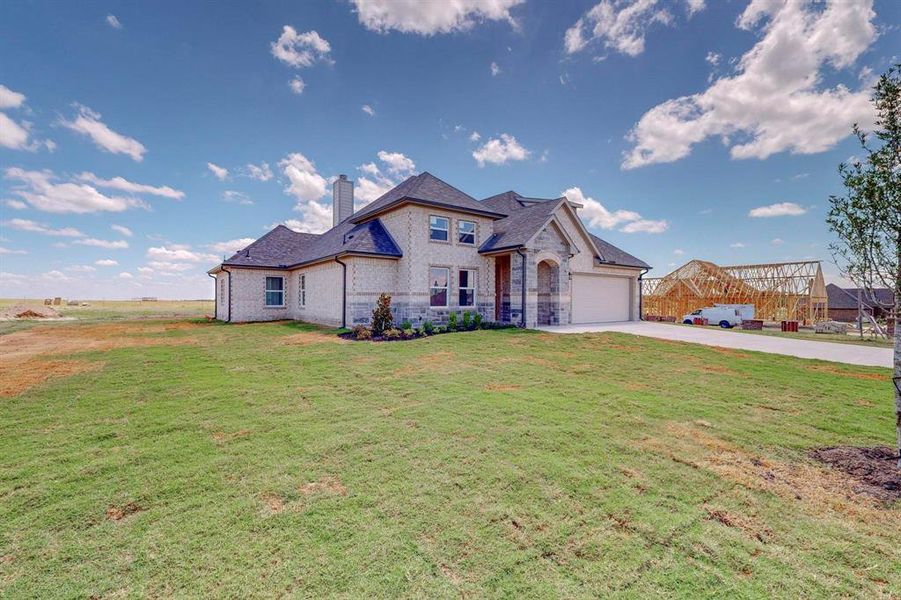 French country style house with a garage and a front yard