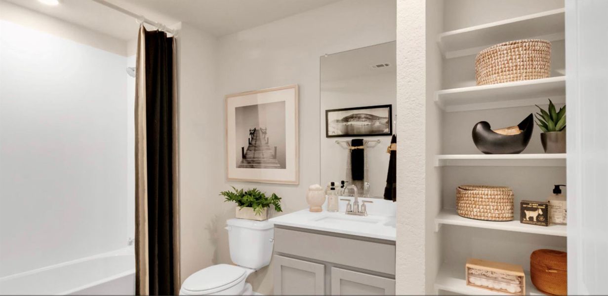 Bathroom with vanity, built in shelves, and tub / shower combination