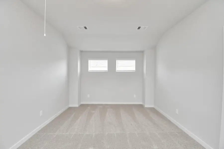 Come upstairs and relish a day of relaxation in this loft area! Ideal as an additional living space or game room, it boasts plush carpeting, high ceilings, custom paint, and windows that flood the area with abundant natural light.