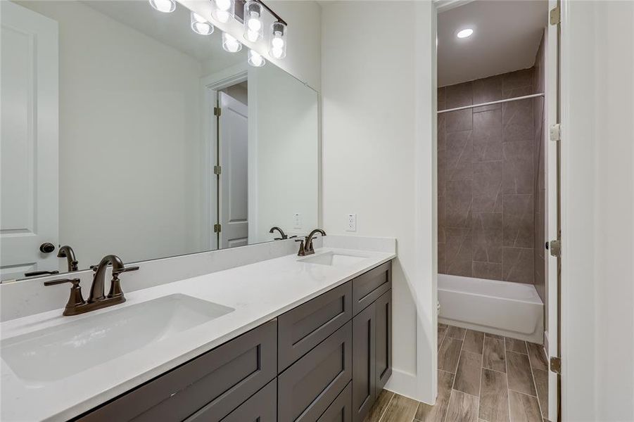 Double vanity in secondary bathroom with wood look tile