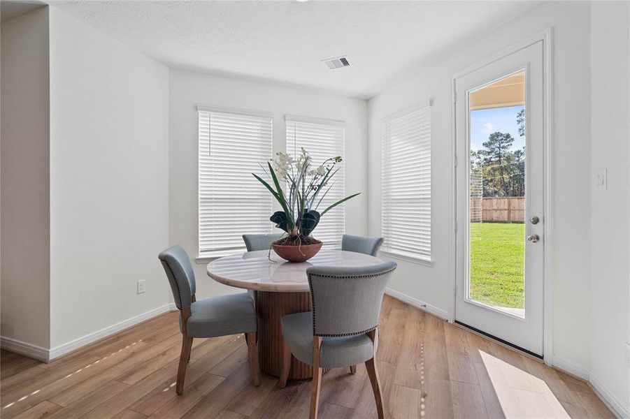 Start your day off right with a cup of coffee sitting with your family in the lovely breakfast area! Featuring large windows with blinds, custom neutral paint, vinyl plank flooring, recessed lighting and high ceilings!