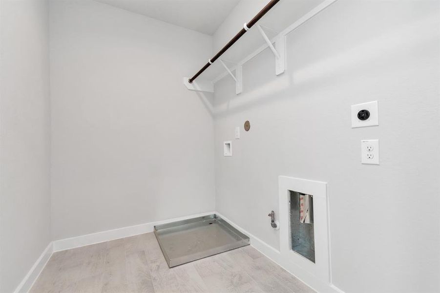 Stylish laundry room where practicality meets a contemporary aesthetic. The dark finishes lend a sophisticated touch, creating a space that is both functional and visually appealing. Both electric and gas connections available. Sample photo of completed home with similar floor plan. As-built interior colors and selections may vary.