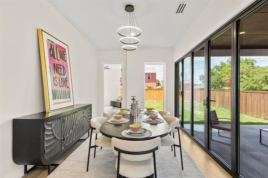Dining area featuring a contemporary chandelier, wood-finish flooring, and a built-in sideboard
