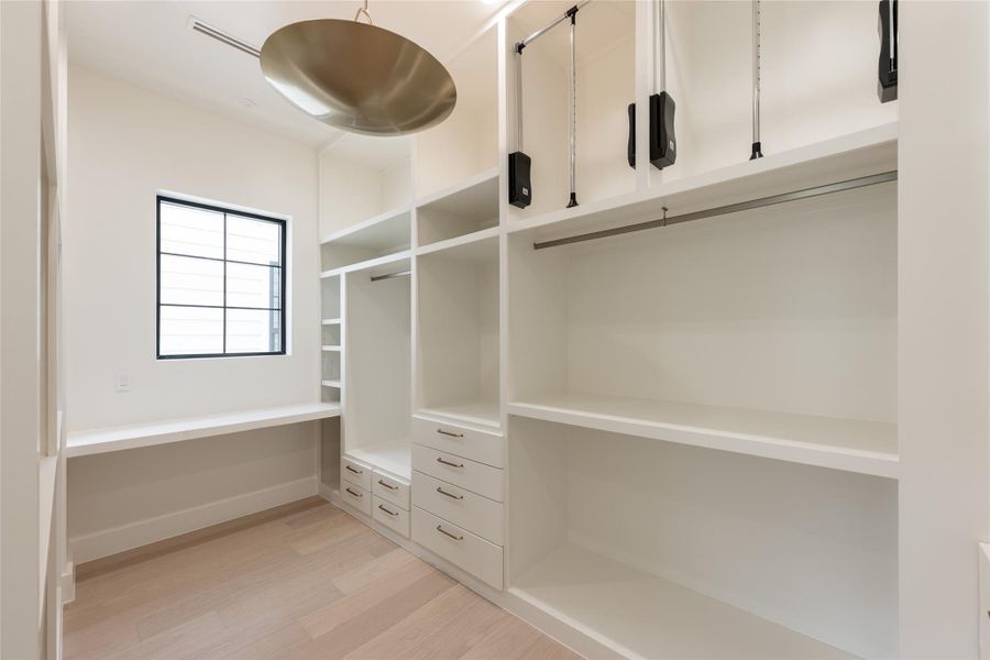 A second view of the primary closet highlights the generous proportions, with extensive custom shelving, hanging space and natural light creating a dressing area that feels open rather than simply utilitarian. A second view of the primary closet highlights the generous proportions, with extensive custom shelving, hanging space and natural light creating a dressing area that feels open rather than simply utilitarian.