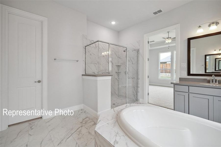 Bathroom featuring vanity, shower with separate bathtub, ceiling fan, and tile patterned floors