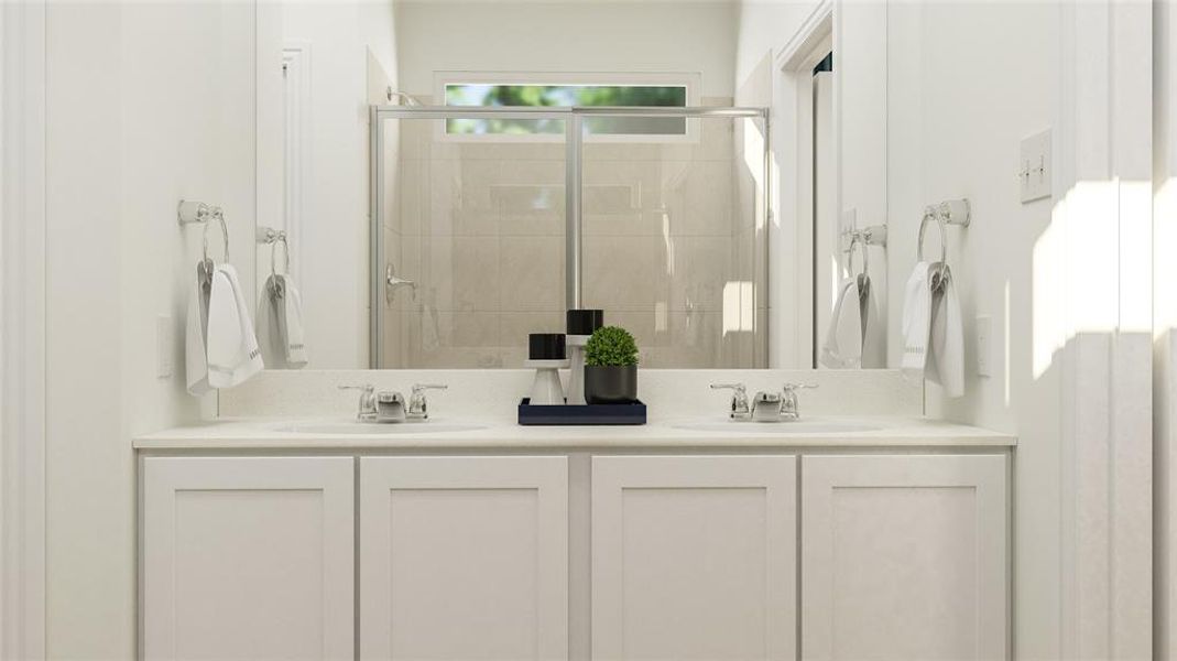 Bathroom featuring dual vanity and a shower with door