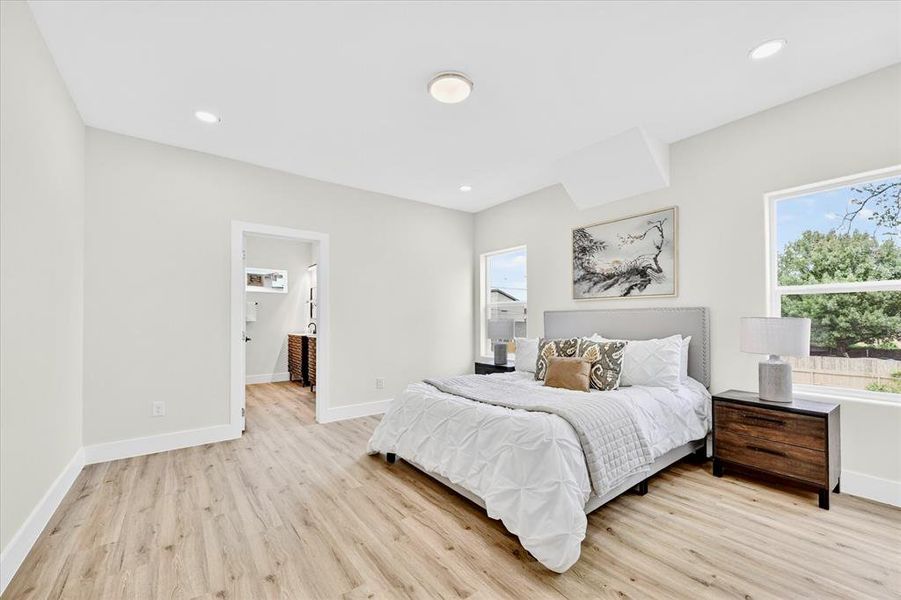 Spacious room with wood-finish flooring, recessed lighting, and white baseboards