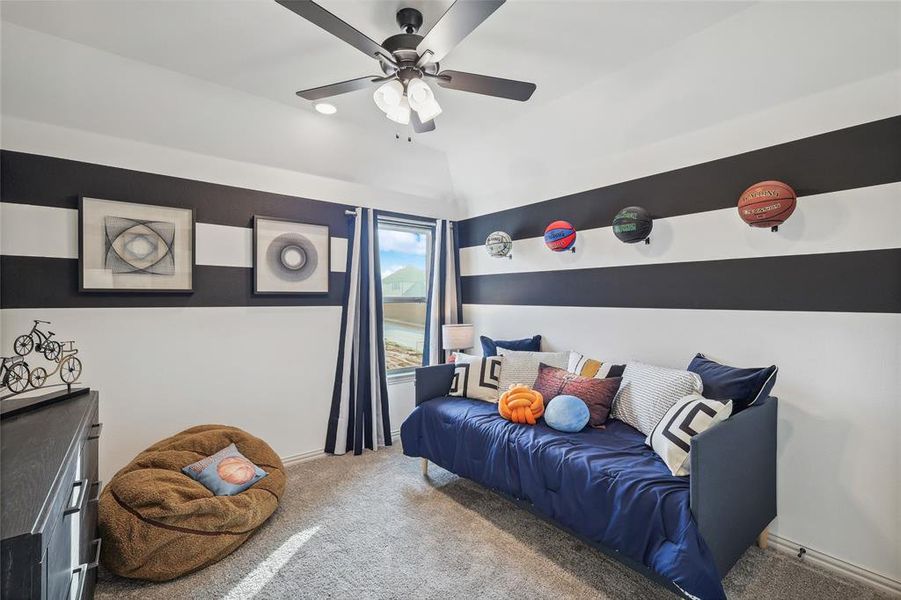 Carpeted bedroom with lofted ceiling and ceiling fan