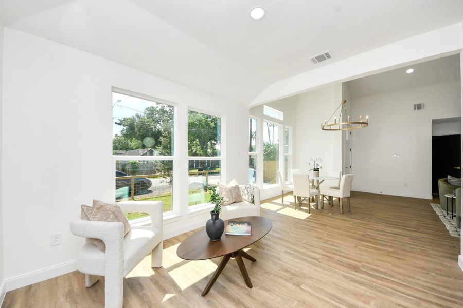 A sleek modern chandelier sets the tone for both casual dinners and special celebrations. Gather around the table as golden sunlight pours in through expansive window. The open layout flows effortlessly into a cozy sitting area—ideal for lingering conversations, entertaining guests, or enjoying quiet moments with family.