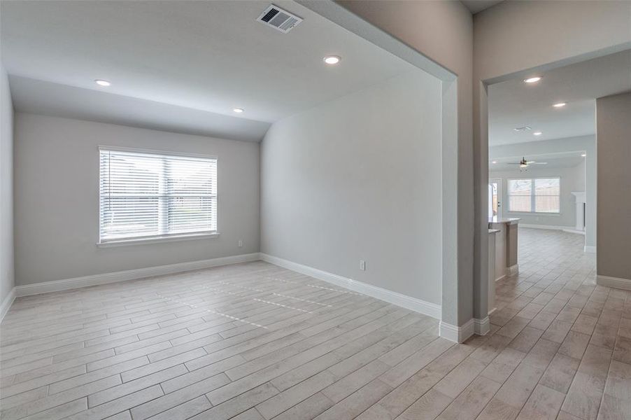 Room featuring light-toned plank-style flooring, white baseboards, and neutral wall paint