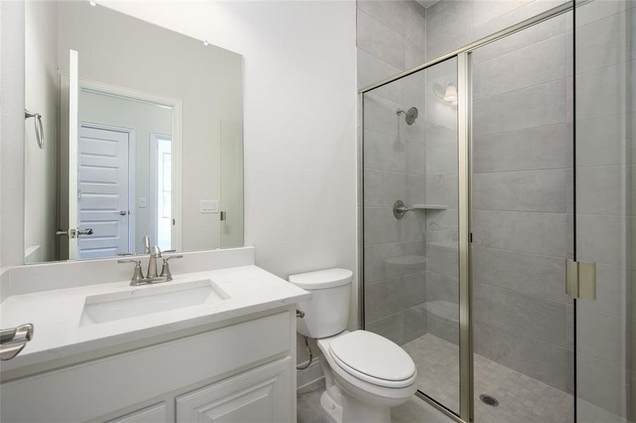 Bathroom with vanity, walk in shower, and toilet