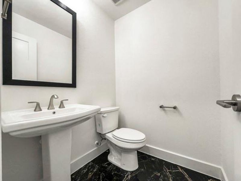Half bathroom featuring baseboards and marble finish floors Half bathroom featuring baseboards and marble finish floors