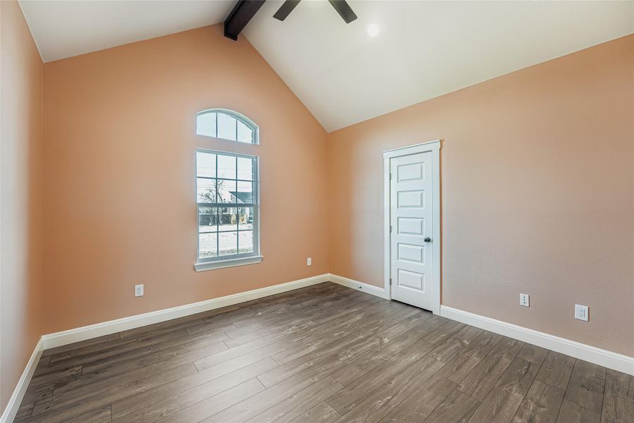 Spare room featuring beam ceiling, wood-type flooring, high vaulted ceiling, and ceiling fan