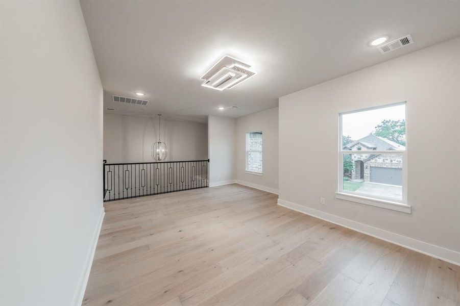 Empty room with light wood-type flooring, a chandelier, and recessed lighting