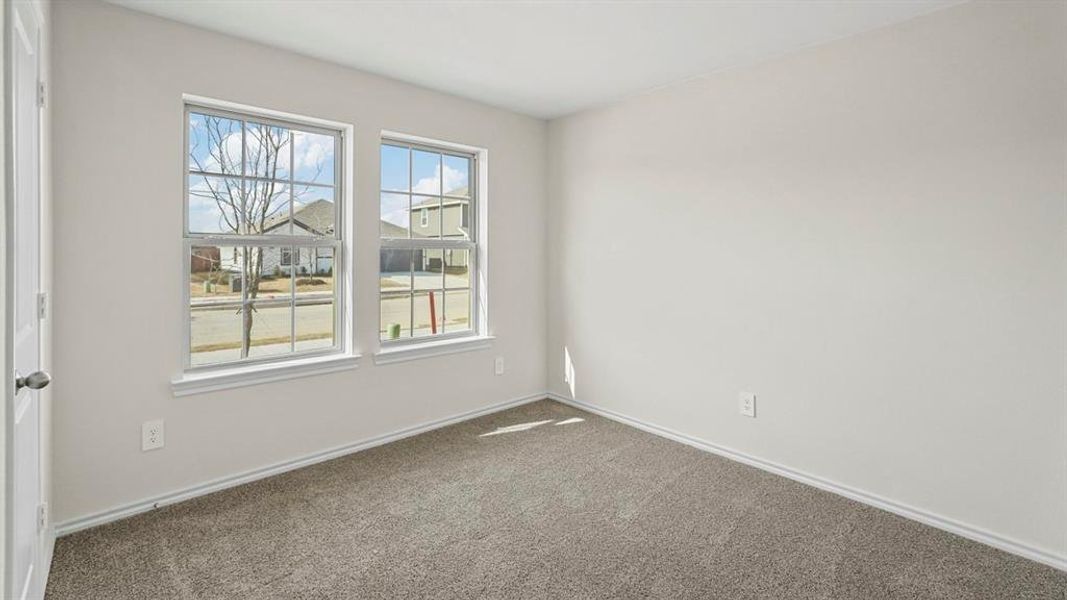Empty room featuring dark carpet and baseboards