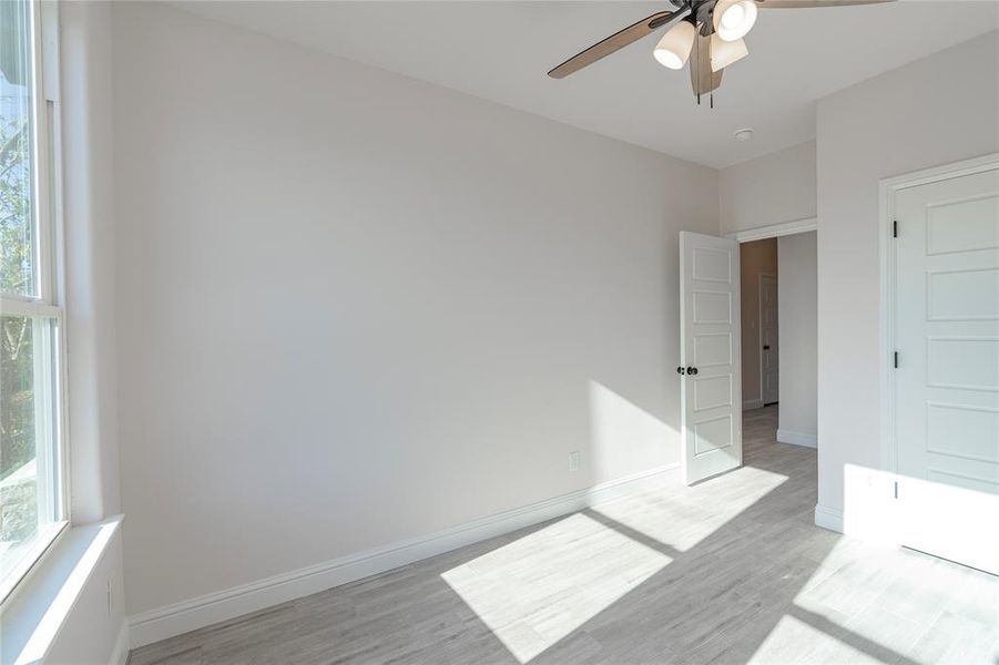 Empty room featuring light wood-type flooring and ceiling fan