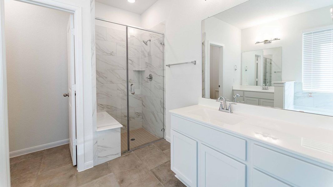 Bathroom with vanity and a marble finish shower