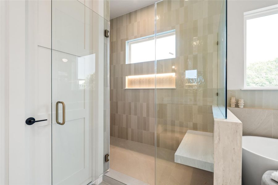 The frameless glass shower is genuinely spacious, with a built-in bench that turns a quick rinse into an actual moment to relax. It's function and comfort working together, not competing.