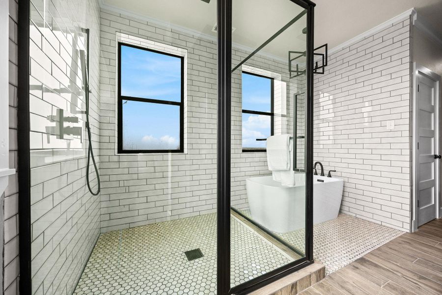 Full bath featuring a shower stall, a soaking tub, and ornamental molding Full bath featuring a shower stall, a soaking tub, and ornamental molding