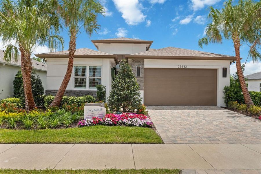 Front exterior of a new home in Valencia Ridge, Wesley Chapel, FL, highlighting curb appeal (Image 1).