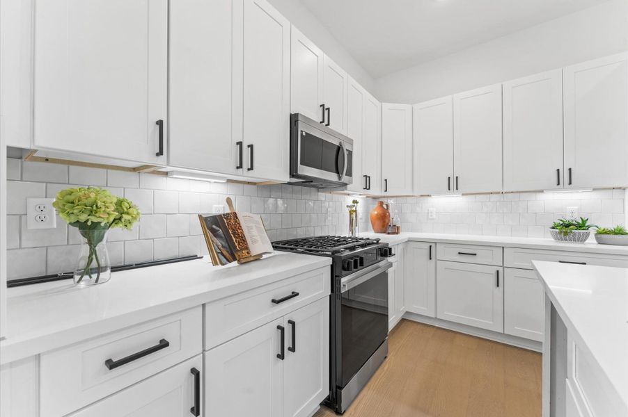 Anchored by a spacious island with bar seating, the kitchen boasts sleek cabinetry, stainless steel appliances, and quartz countertops.