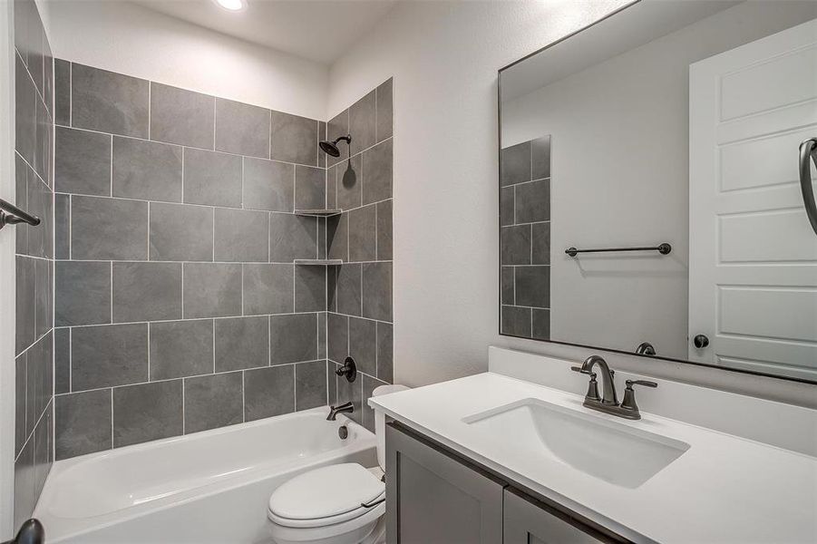 Bathroom featuring toilet, vanity, and shower combination Bathroom featuring toilet, vanity, and shower combination