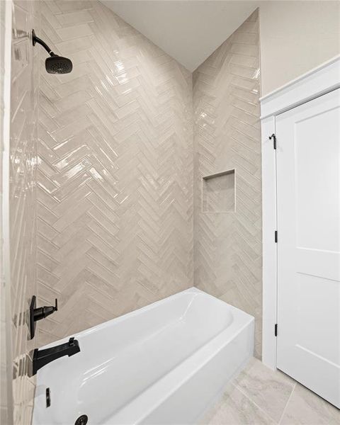 Bathroom with tub / shower combination and tile walls