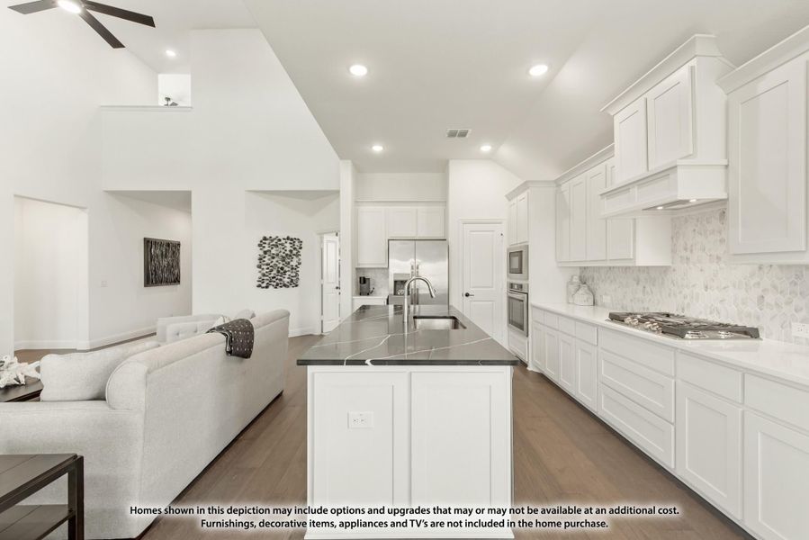 Open-concept kitchen with white cabinets, dark marble island, and hardwood floors, open to living area with high ceilings Open-concept kitchen with white cabinets, dark marble island, and hardwood floors, open to living area with high ceilings