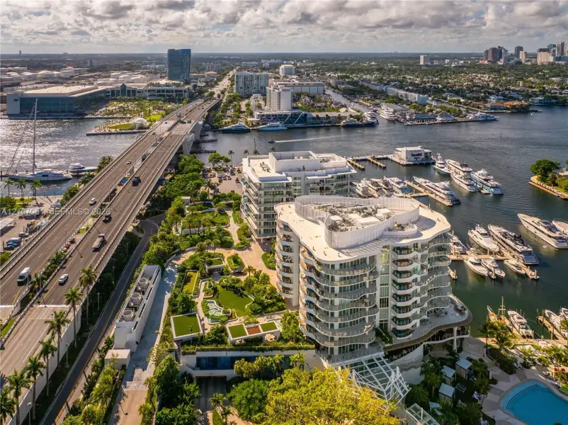 Waterfront multi-story residential building featuring wrap-around balconies, landscaped grounds, a swimming pool, and private boat slips Waterfront multi-story residential building featuring wrap-around balconies, landscaped grounds, a swimming pool, and private boat slips