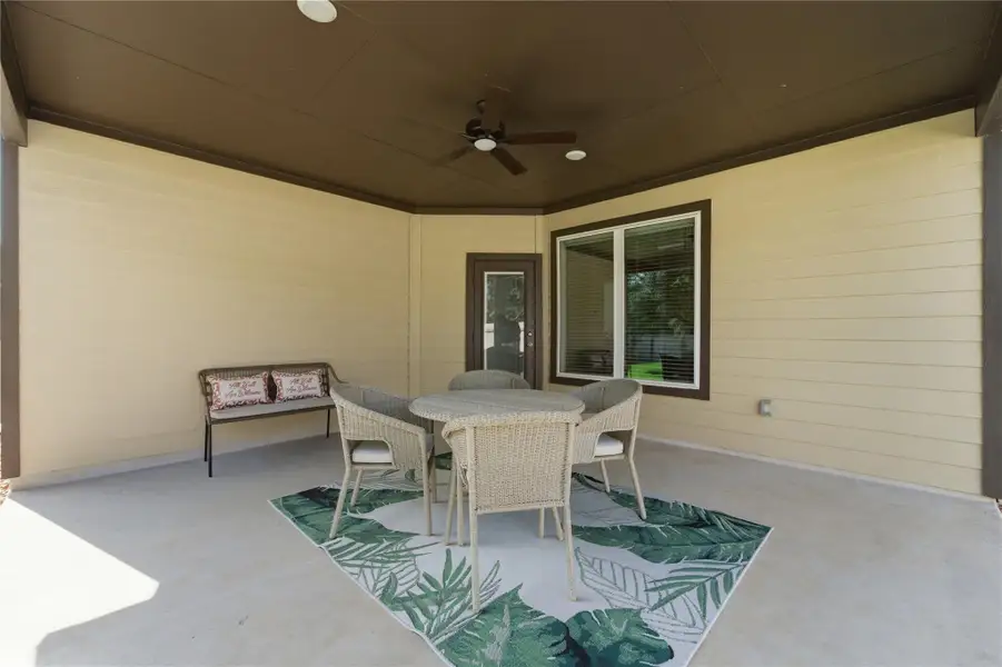 An inviting outdoor patio, perfect for leisurely afternoons, features a ceiling fan for comfort. An inviting outdoor patio, perfect for leisurely afternoons, features a ceiling fan for comfort.