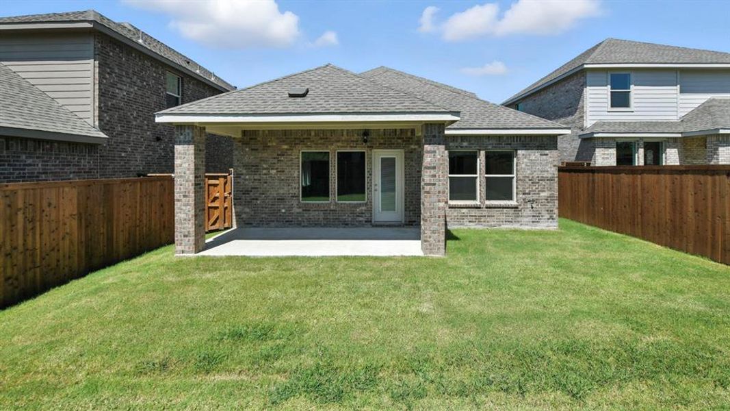 Back of property with a patio area, a fenced backyard, brick siding, and roof with shingles Back of property with a patio area, a fenced backyard, brick siding, and roof with shingles
