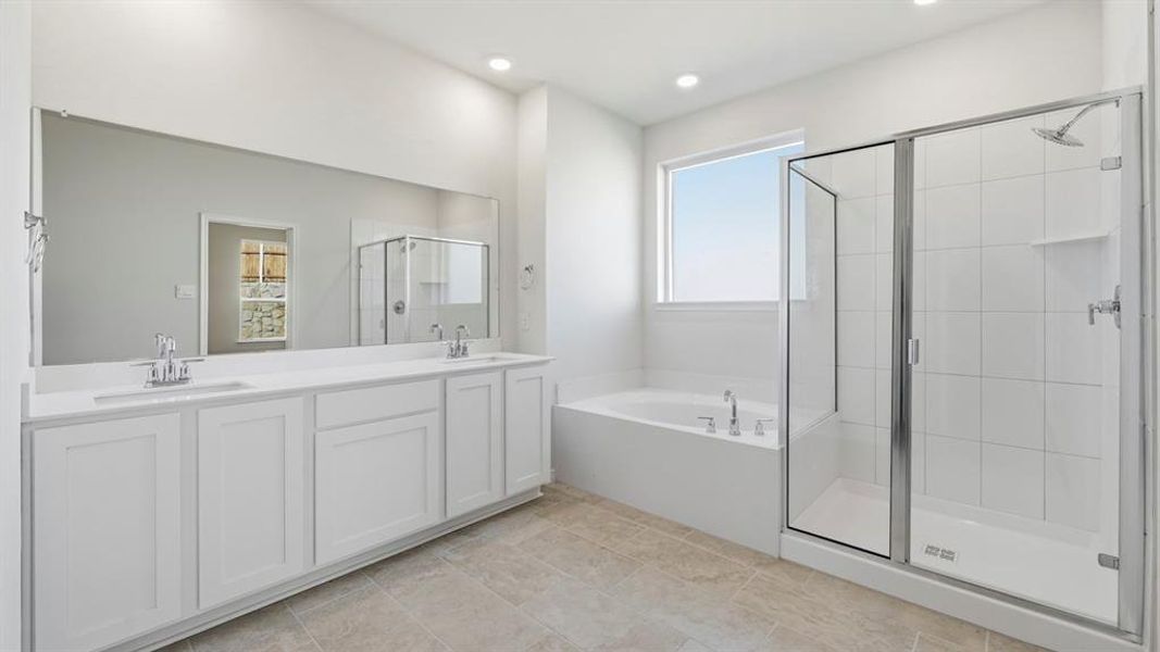 Bathroom featuring double vanity, a garden tub, a shower stall, light tile patterned flooring, and recessed lighting Bathroom featuring double vanity, a garden tub, a shower stall, light tile patterned flooring, and recessed lighting