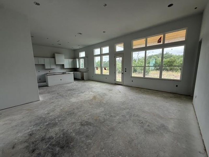 A spacious, open-concept interior featuring tall windows, offering plentiful natural illumination and scenic views.
