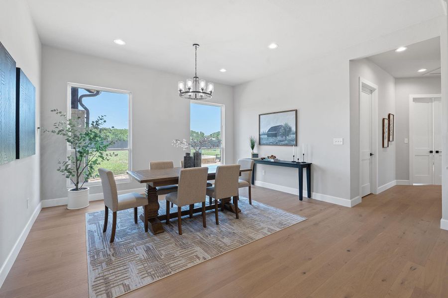 Dining area with light wood-style flooring, a chandelier, and recessed lighting