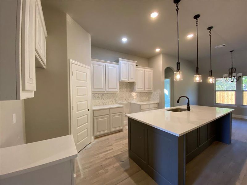 Kitchen features cabinet wrapped island in Gaunlet Grey & Calacatta Lincoln quartz which seems like a custom furniture piece (hardwoods not stained Aged Barrel Grey w/Black tint yet) Kitchen features cabinet wrapped island in Gaunlet Grey & Calacatta Lincoln quartz which seems like a custom furniture piece (hardwoods not stained Aged Barrel Grey w/Black tint yet)