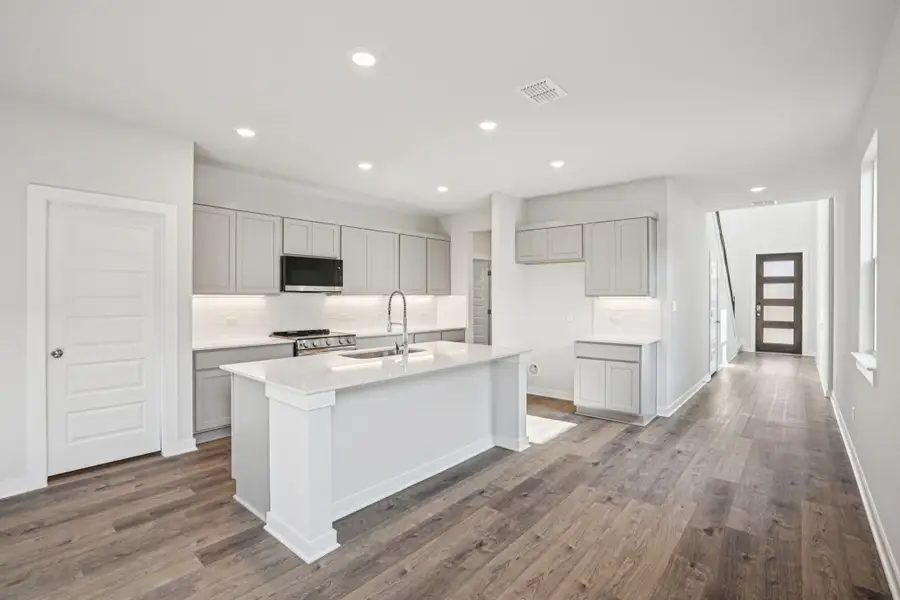A kitchen with white cabinets.