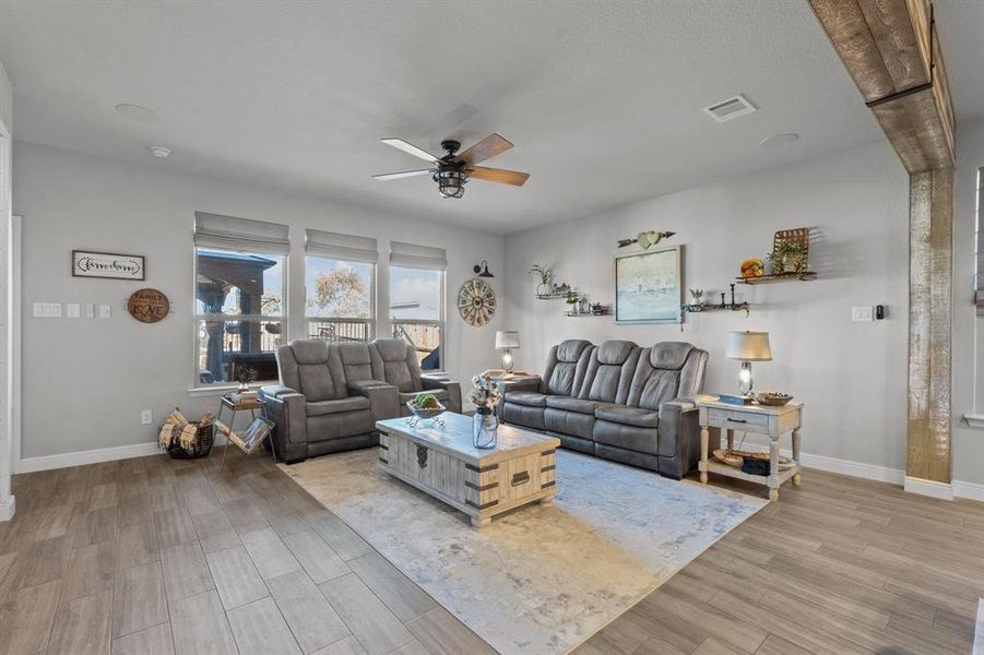 Living room with ceiling fan and light hardwood / wood-style flooring