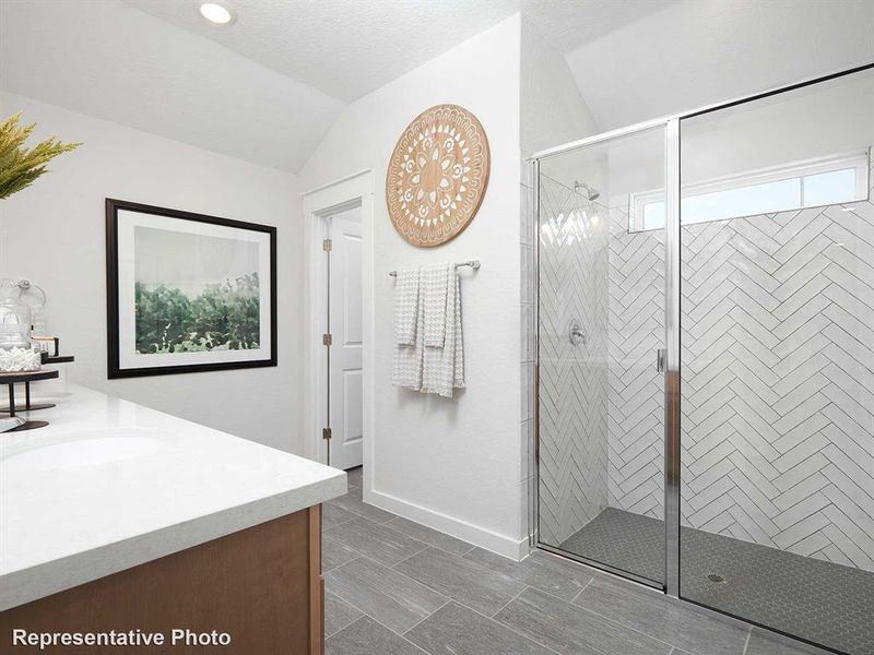 Bathroom featuring a glass-enclosed shower with herringbone tile walls and a tiled floor